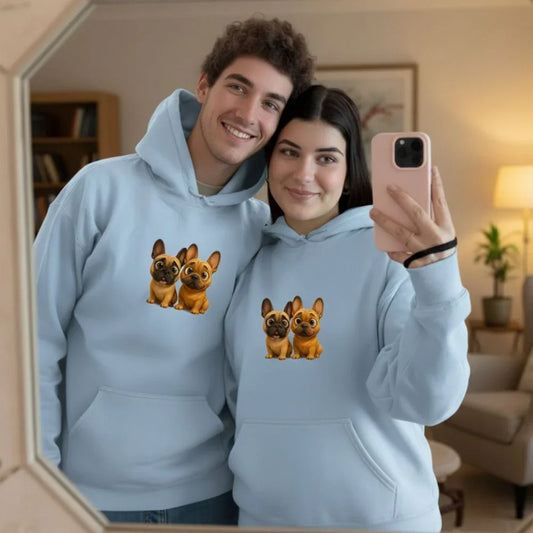 Smiling young couple in matching light blue hoodies with cartoon French bulldog design taking mirror selfie